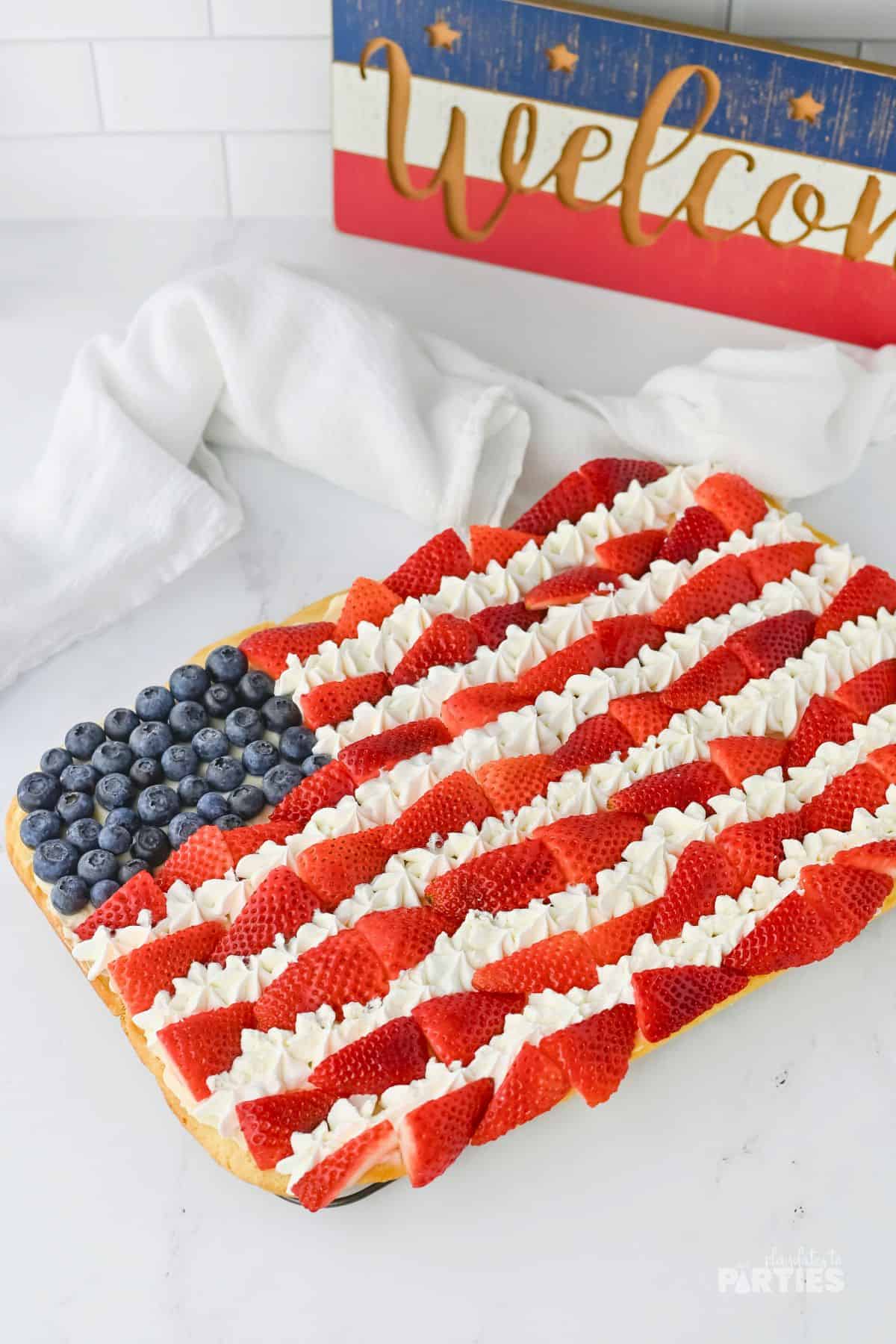 July 4th dessert decorated like a flag with fruit and a sugar cookie crust.
