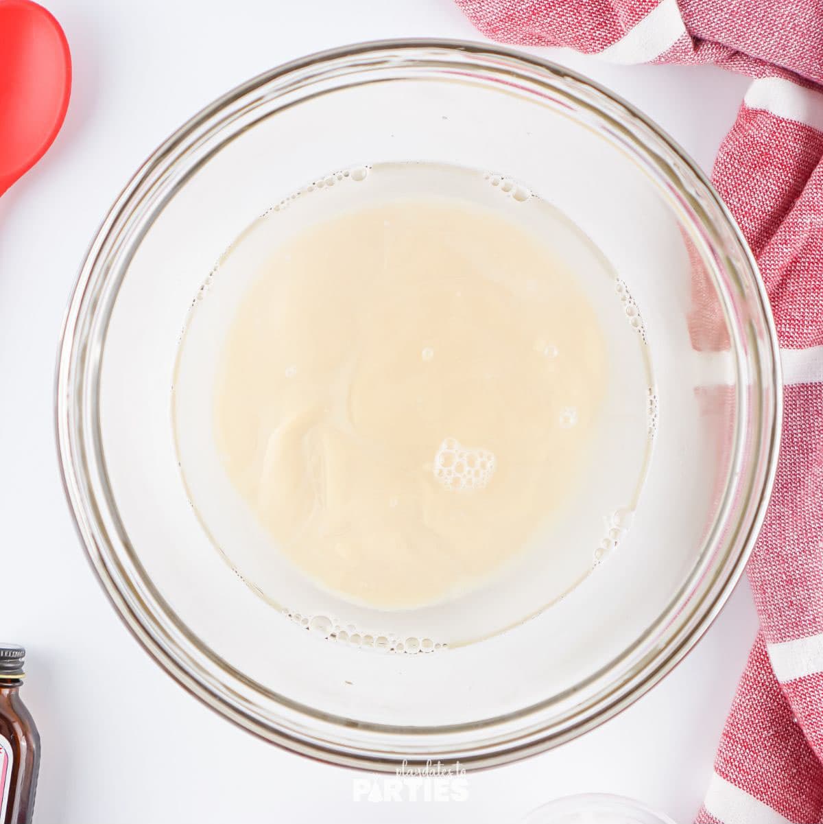 Sweetened condensed milk in a bowl of gelatin and water.