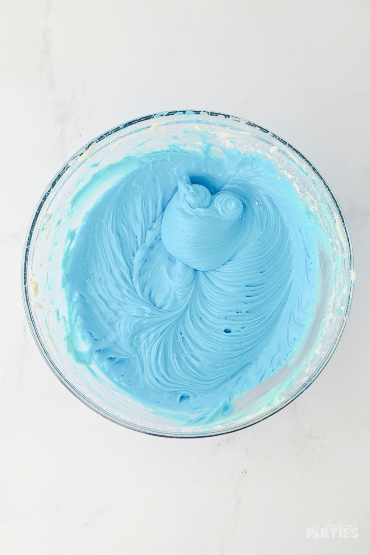 The blue cheesecake layer mixed in a bowl.