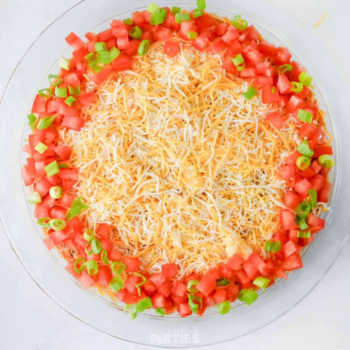 Adding a ring of fresh tomatoes and green onions.