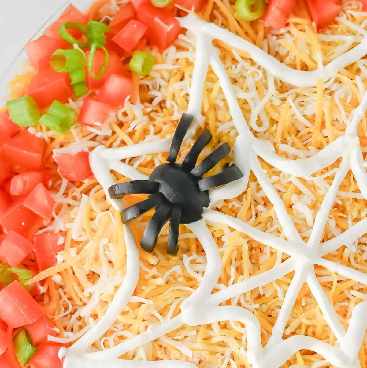 An edible spider made from black olives.