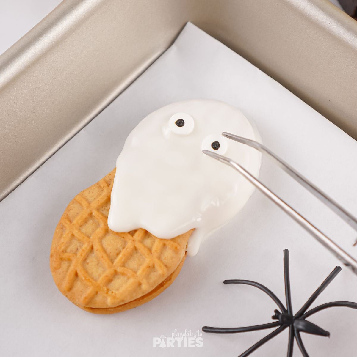 Adding candy eyes to the cookie.