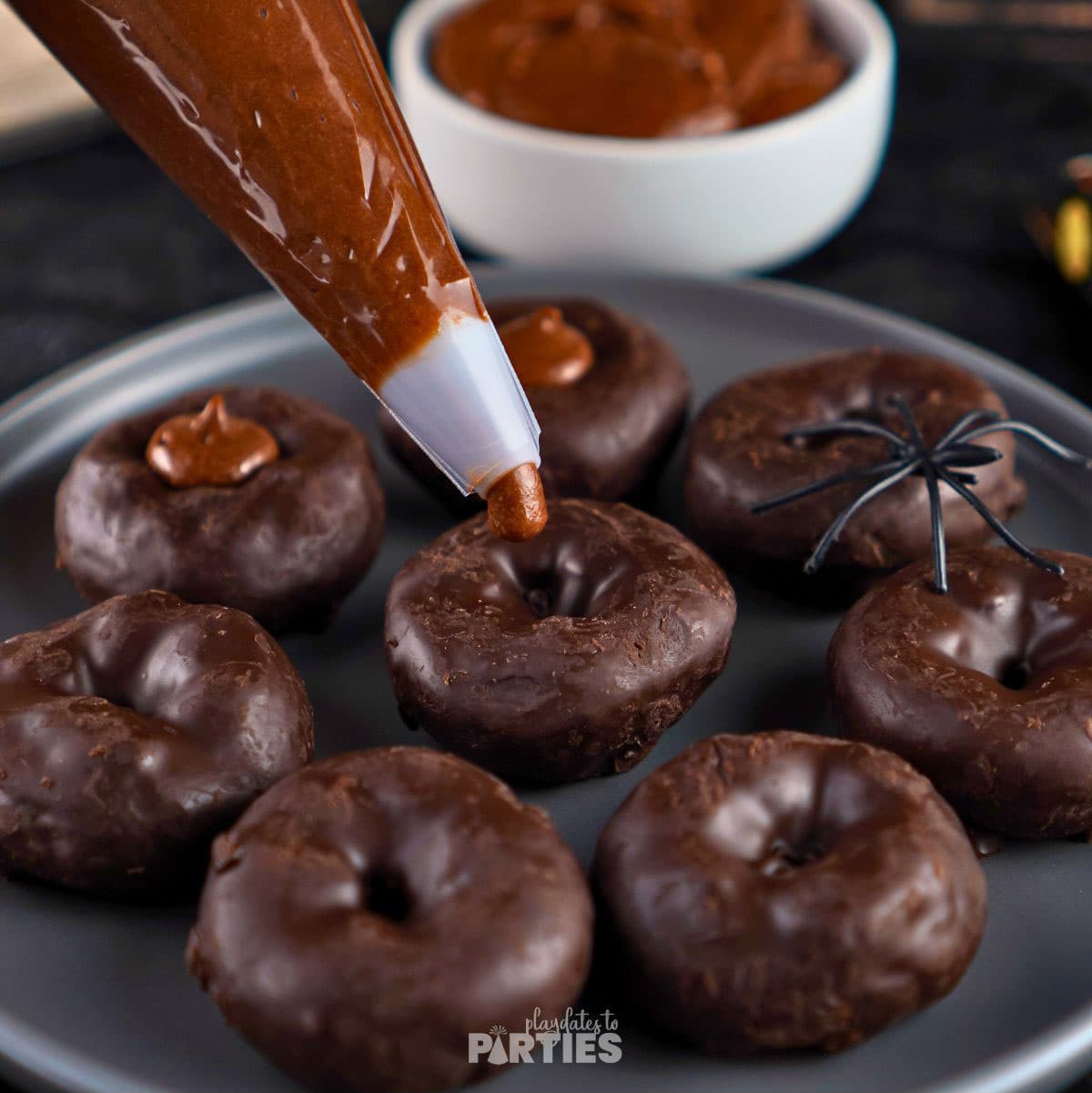Adding frosting to a mini donut.