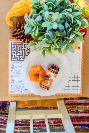 Overhead view of a kids table with a printable Thanksgiving placemat.