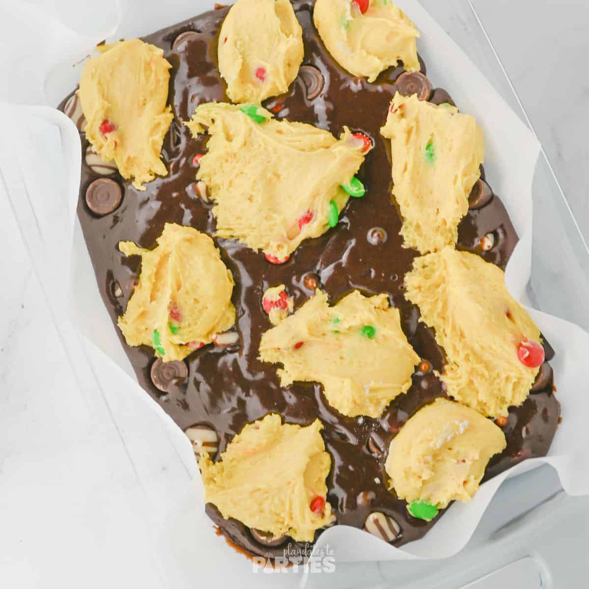 Cake mix dolloped on top of brownie mix.