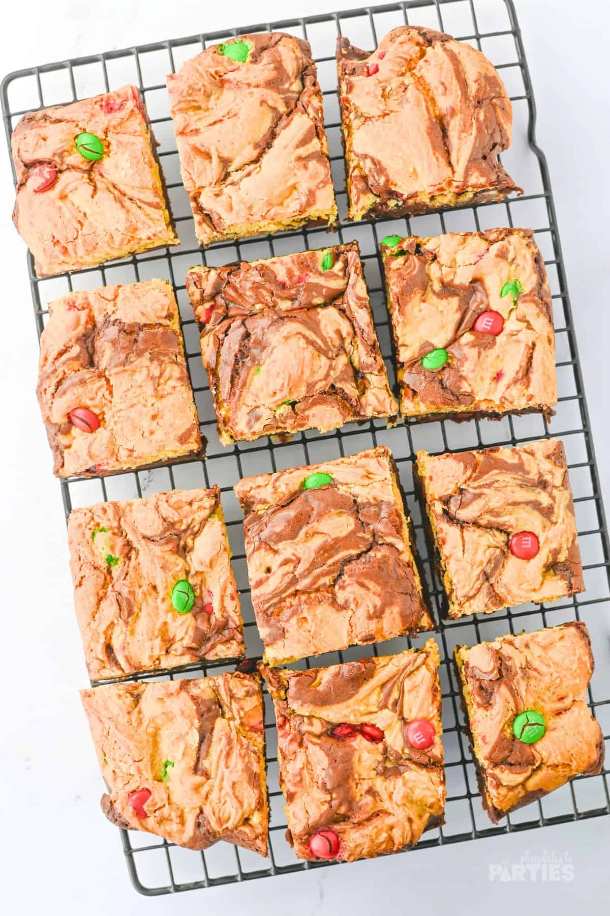 Layered holiday brownies cooling on a rack.