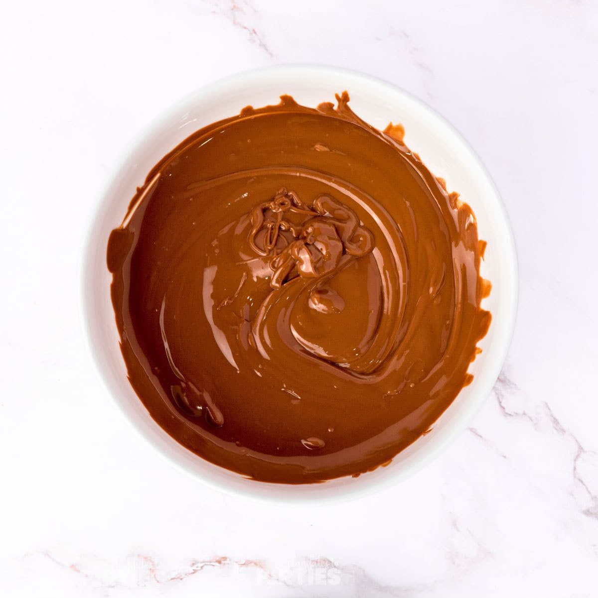 Melted chocolate in a white bowl.
