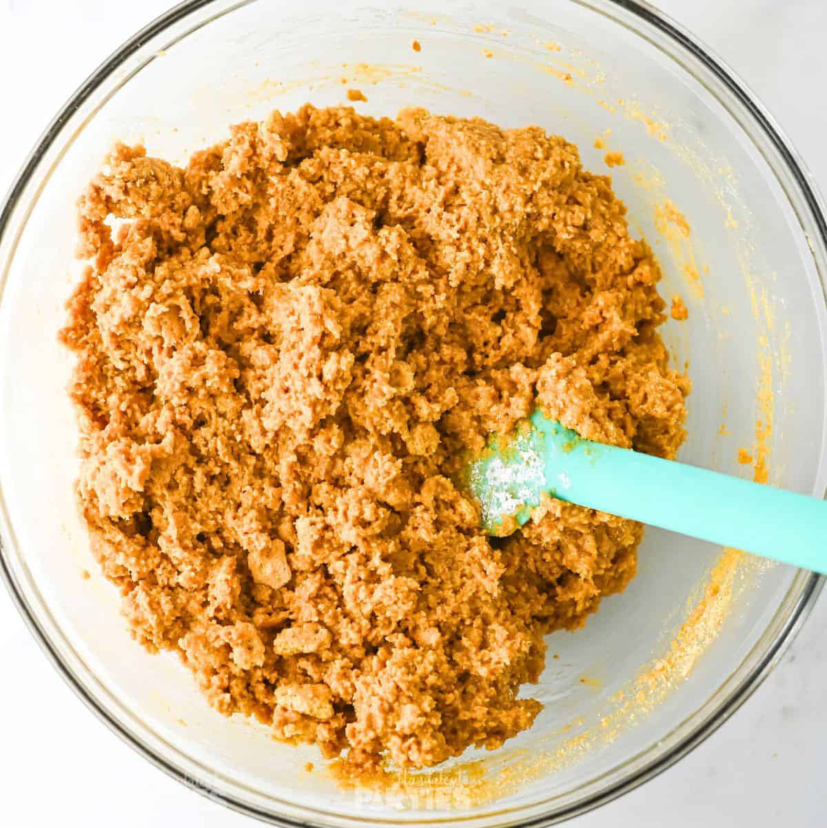 Stirring in peanut butter and graham cracker crumbs.