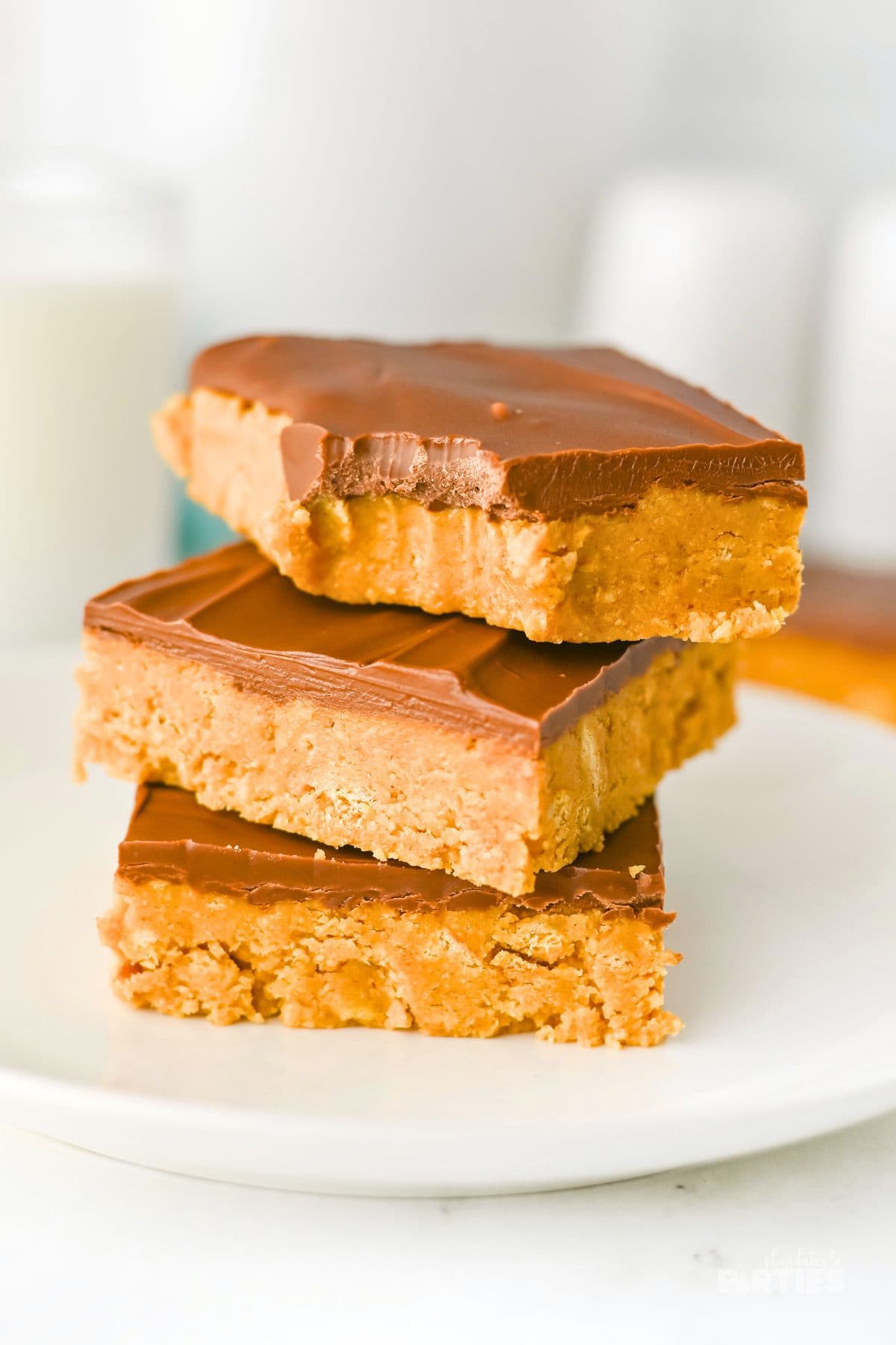 Three Peanut Butter Bars stacked on a white plate.
